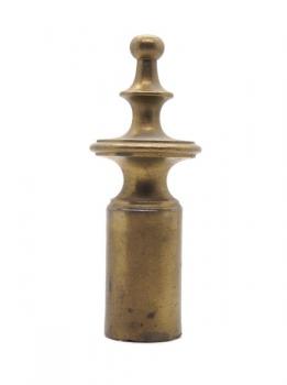 The brass finial cap of the curtain rod